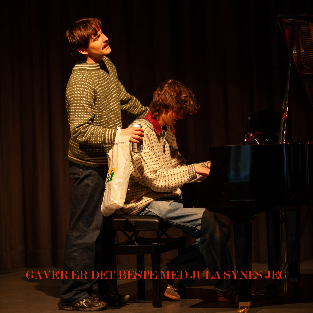Two guys, one sitting at the piano playing, the other with his hands on the man playing piano's shoulders, head back, eyes closed, singing a song.